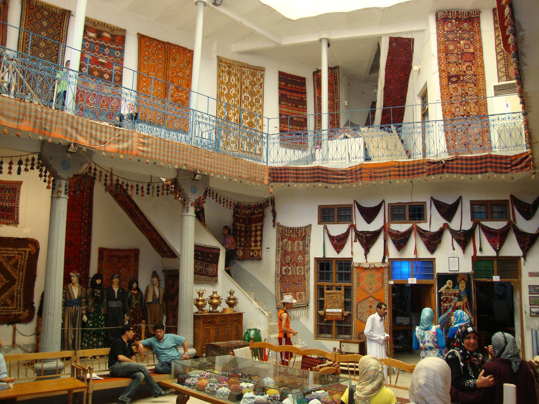 a room with a lot of people sitting around - File:Kurdish Textile Museum Hewler Citadel.jpg